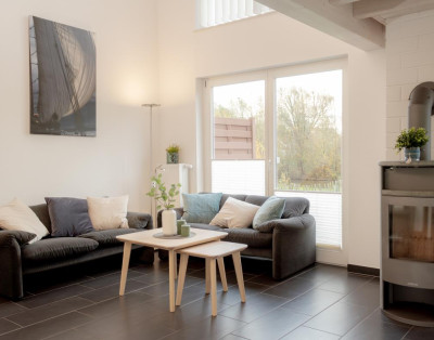 Gemütlicher Wohnbereich mit Kamin und Blick ins Grüne