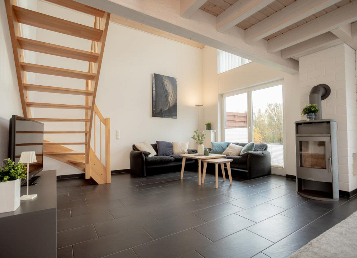 Großzügiger Wohnraum mit Kamin und Blick ins Grüne