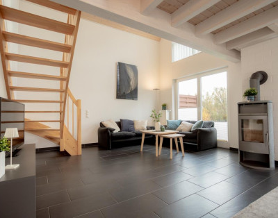 Großzügiger Wohnraum mit Kamin und Blick ins Grüne