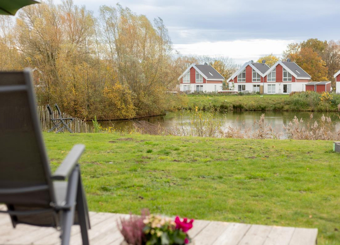 Blick von der Terrasse über den See auf die Ferienhäuser