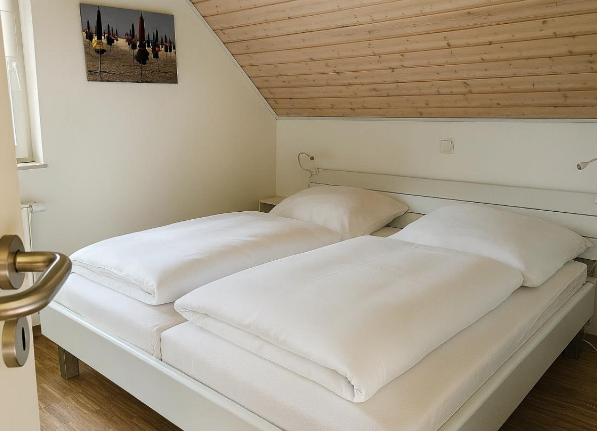 zweites gemütliches Schlafzimmer mit Doppelbett unter der Dachschräge Dock 61