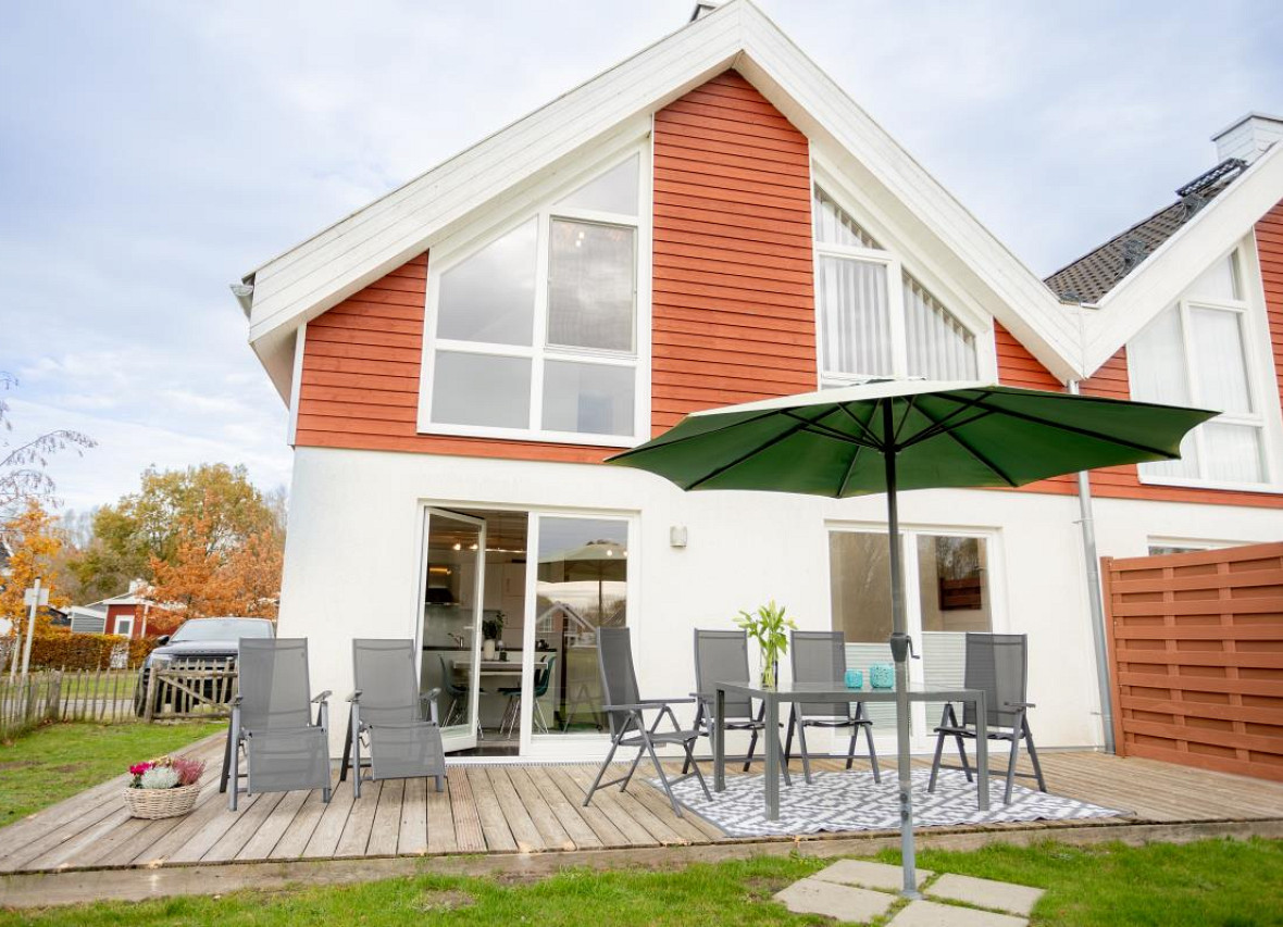 Großzügige Terrasse des Ferienhauses Dock 61 mit Essbereich und Liegestühlen